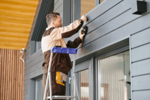young-man-uniform-holding-alarm-system-while-standing-ladder_274679-21931 (1)
